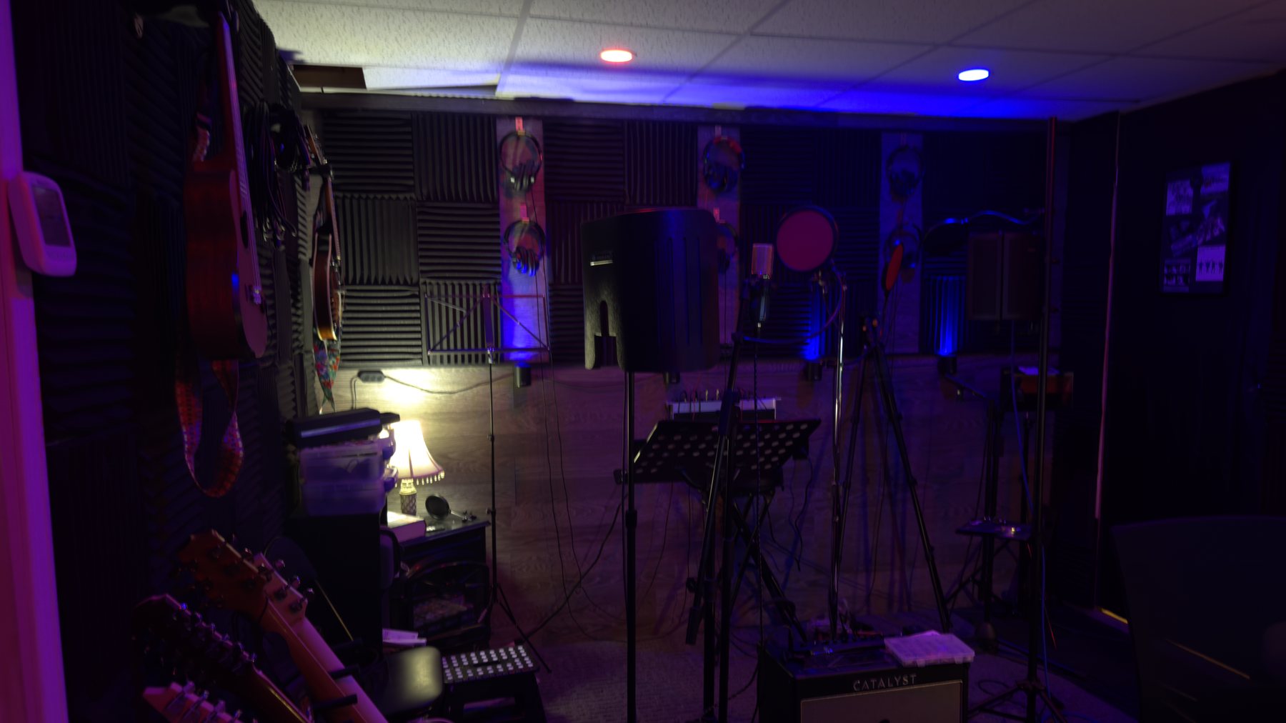 Le studio de Pierre Dassylva, éclairé aux néons, avec guitares et matériel d'enregistrement